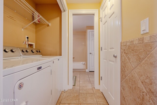 laundry area with light tile patterned flooring and washer and clothes dryer