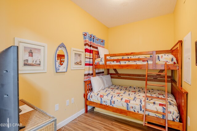 bedroom with a textured ceiling and hardwood / wood-style flooring