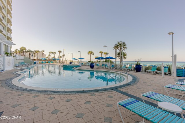 pool at dusk with a patio