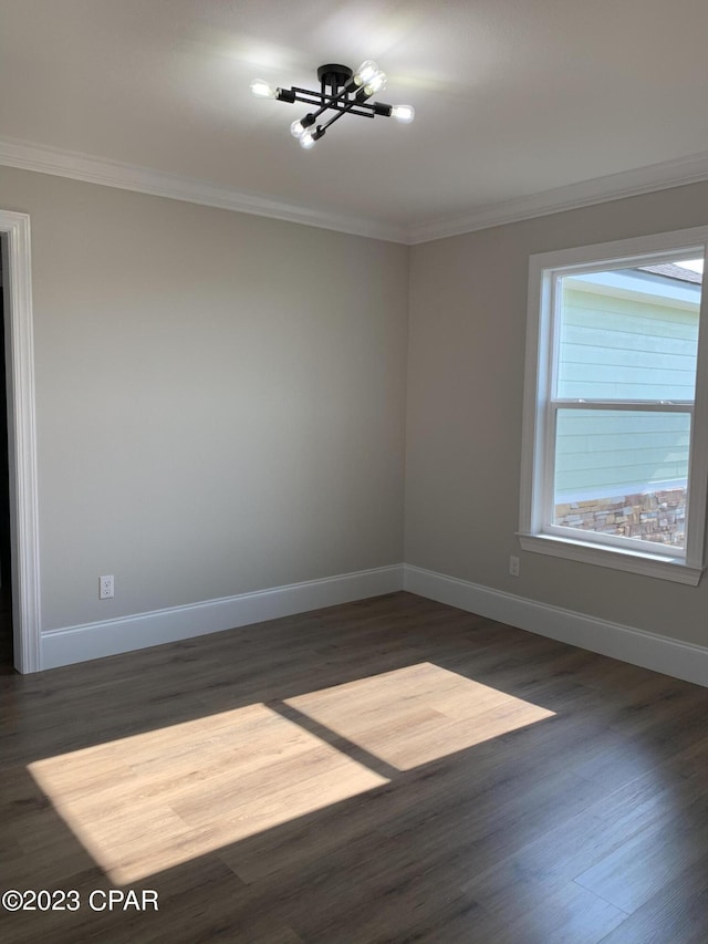 unfurnished room featuring dark hardwood / wood-style flooring, crown molding, and a chandelier