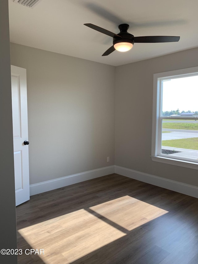 spare room with ceiling fan and dark wood-type flooring