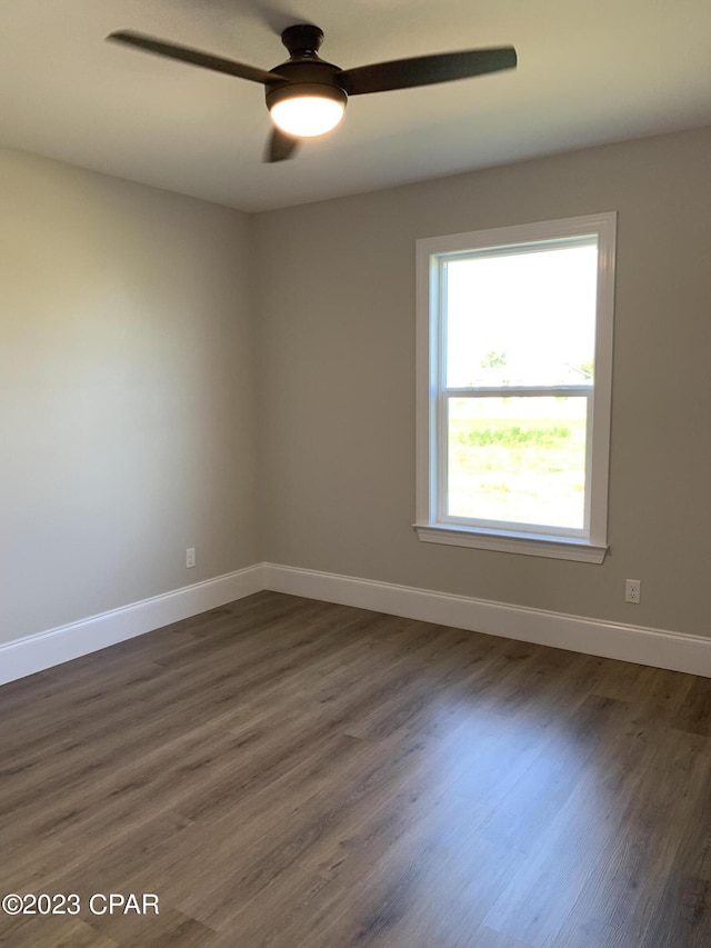 empty room with ceiling fan and dark wood-type flooring