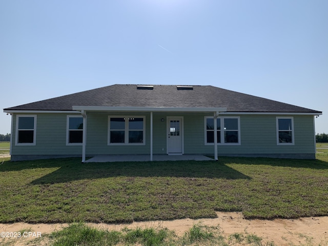 rear view of property with a patio area and a lawn