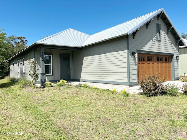 view of front of property featuring a front yard and a garage