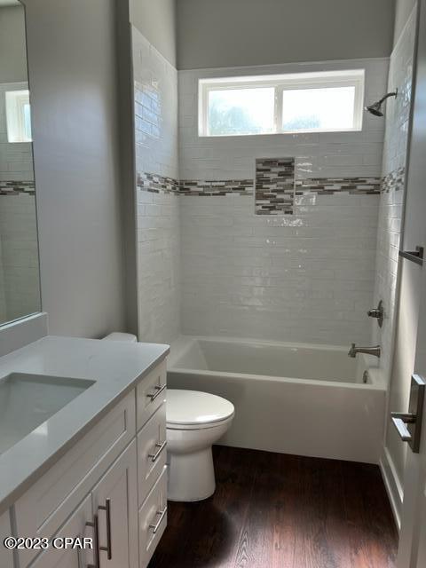 full bathroom featuring wood-type flooring, tiled shower / bath combo, plenty of natural light, and vanity