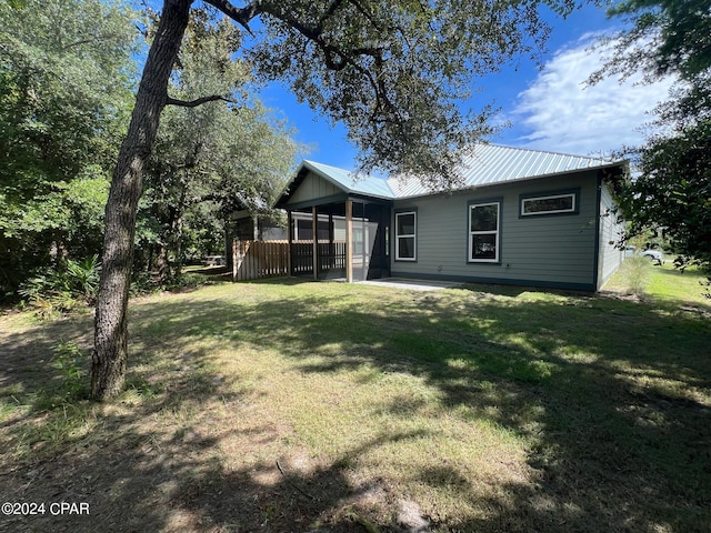 rear view of property with a lawn and a patio