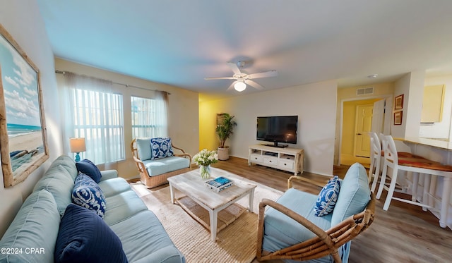 living room with light hardwood / wood-style floors and ceiling fan