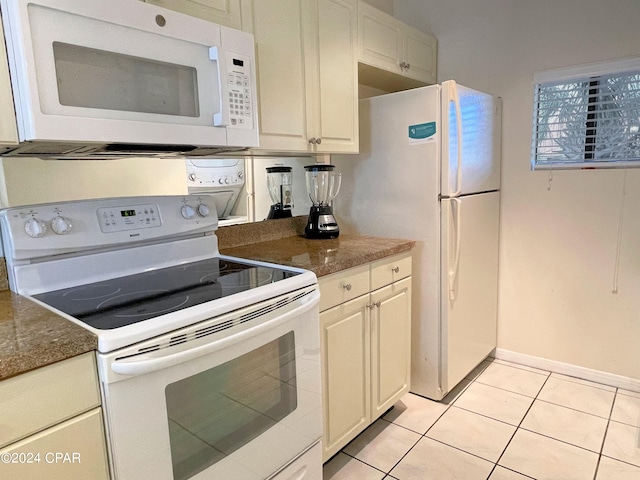 kitchen with white appliances, light tile patterned flooring, and white cabinetry