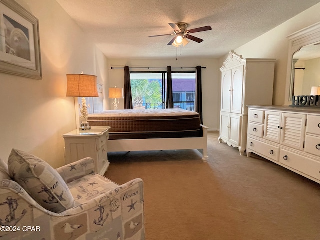 carpeted bedroom featuring ceiling fan and a textured ceiling