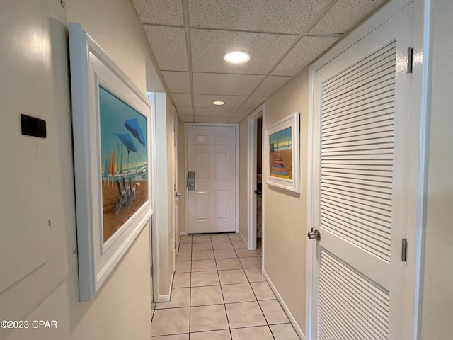 corridor featuring a drop ceiling and light tile patterned floors