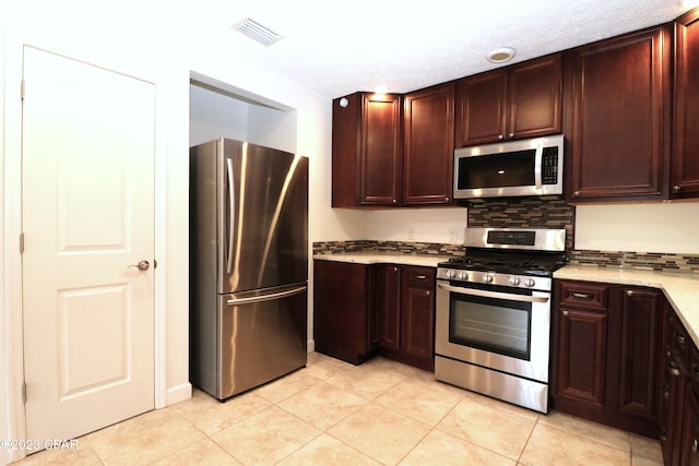 kitchen featuring appliances with stainless steel finishes, light tile patterned floors, and tasteful backsplash