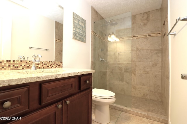 bathroom with tiled shower, a textured ceiling, vanity, and toilet