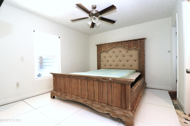 tiled bedroom featuring a textured ceiling and ceiling fan