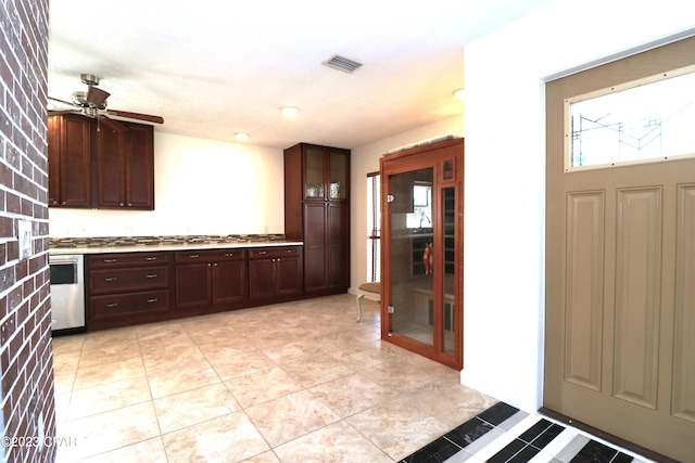 kitchen with dishwasher, ceiling fan, brick wall, and dark brown cabinetry