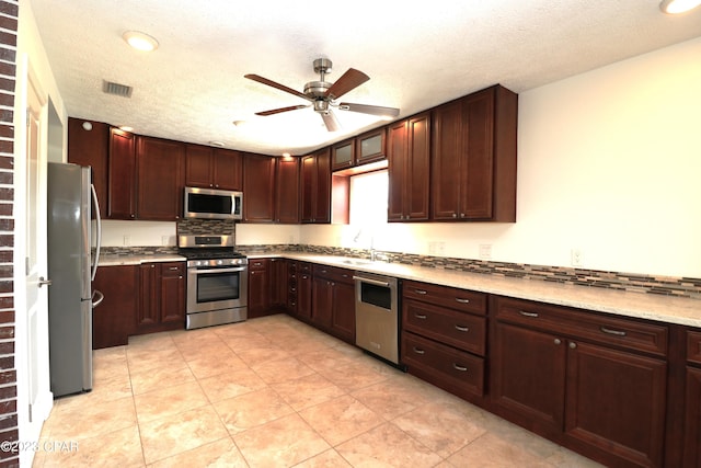 kitchen featuring ceiling fan, a textured ceiling, appliances with stainless steel finishes, and light tile patterned flooring