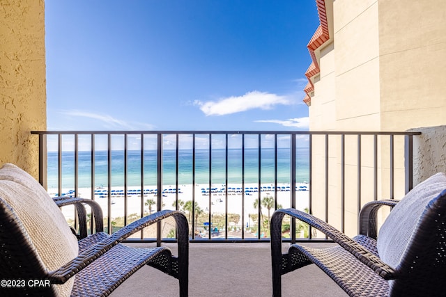 balcony with a beach view and a water view