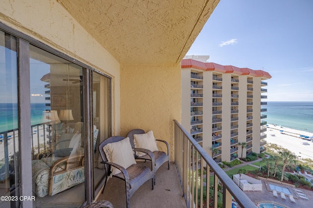 balcony featuring a beach view and a water view