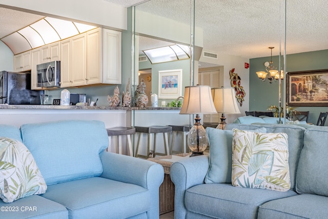 living room featuring an inviting chandelier and a textured ceiling