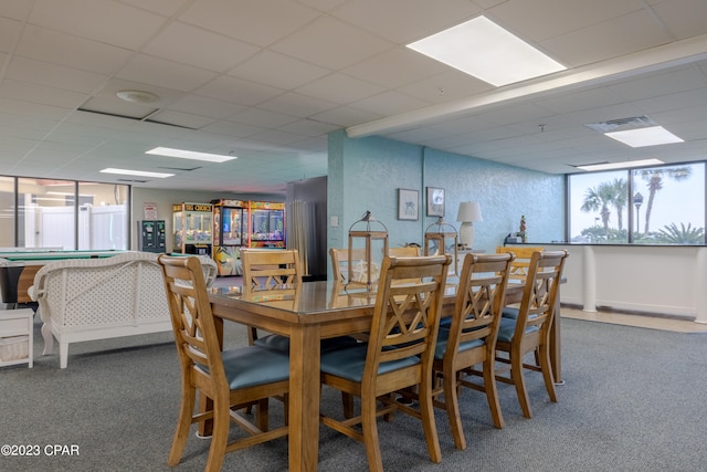 dining room featuring a drop ceiling and dark carpet