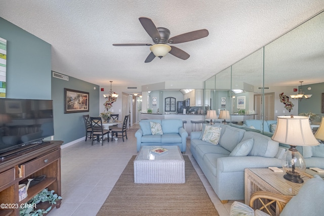 tiled living room with a textured ceiling and ceiling fan with notable chandelier