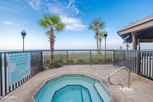 view of swimming pool featuring a patio and a hot tub