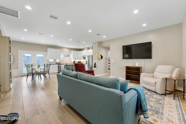 living room featuring light hardwood / wood-style floors and french doors