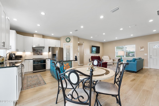 dining space featuring sink and light hardwood / wood-style floors