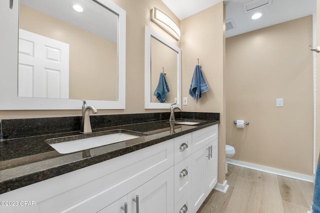 bathroom with hardwood / wood-style floors, toilet, and vanity