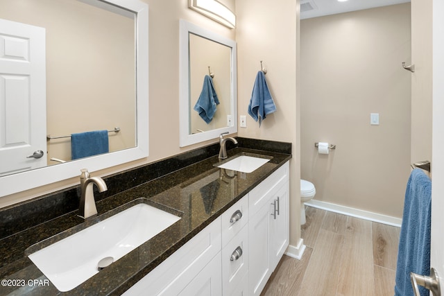 bathroom featuring toilet, hardwood / wood-style flooring, and vanity