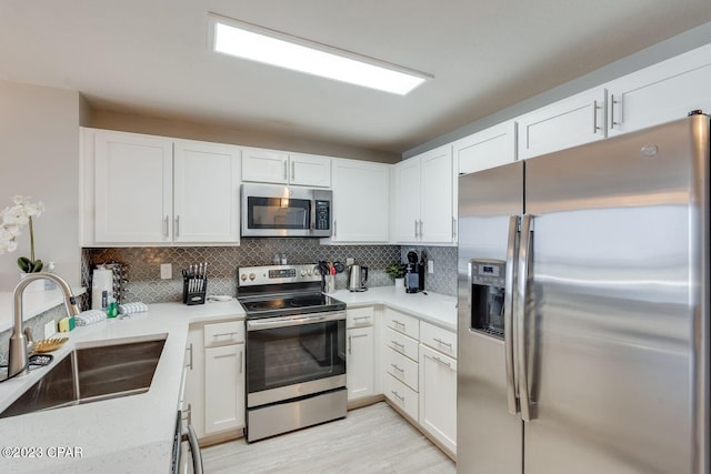 kitchen featuring sink, appliances with stainless steel finishes, and white cabinetry