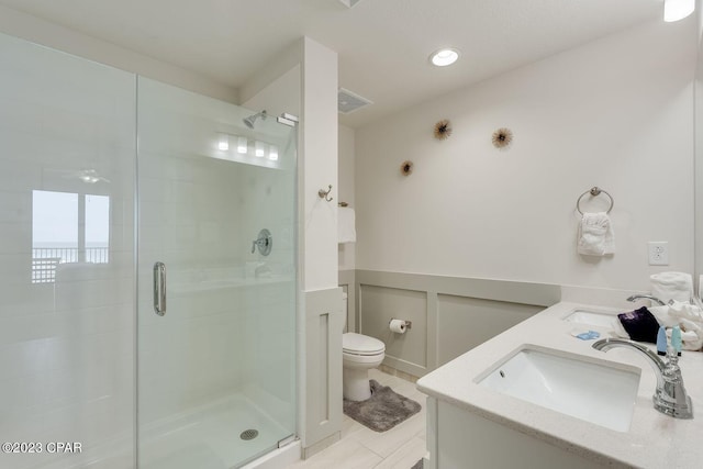 bathroom with vanity, toilet, and a shower with shower door