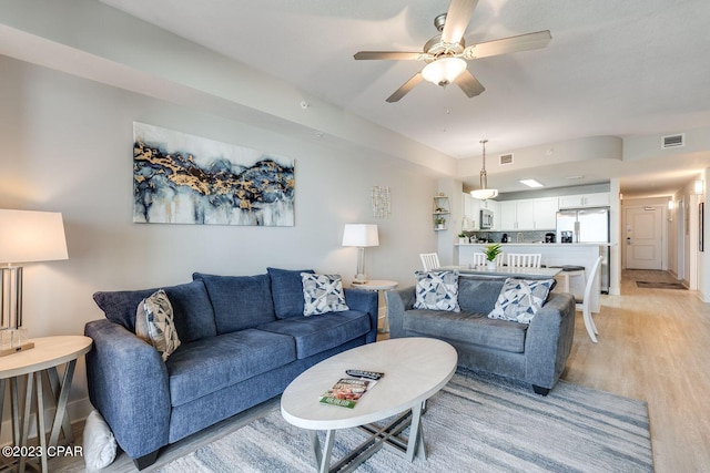 living room featuring light wood-type flooring and ceiling fan