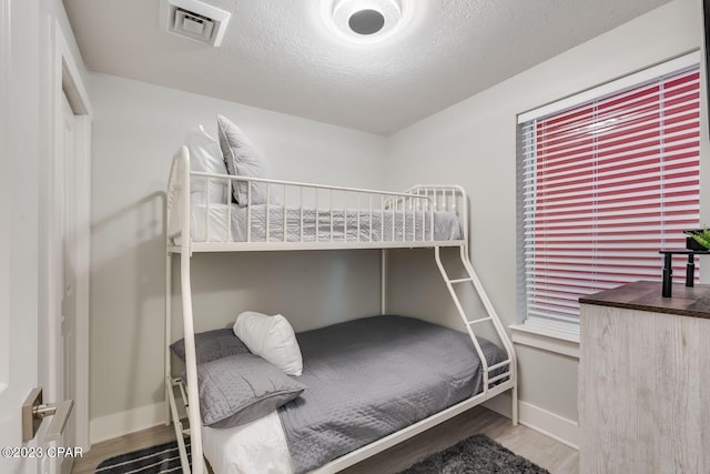 bedroom with hardwood / wood-style floors and a textured ceiling