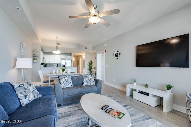 living room featuring light wood-type flooring and ceiling fan