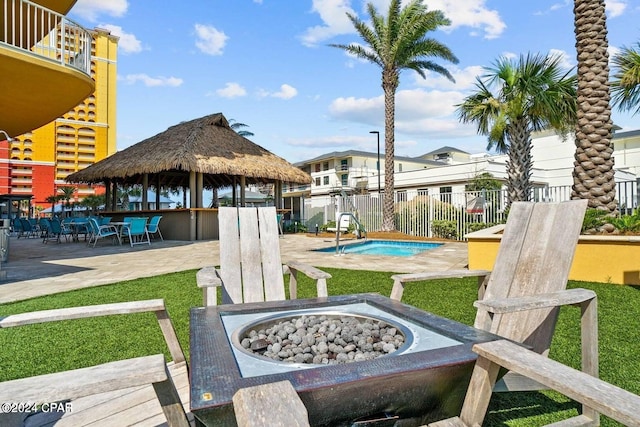 exterior space featuring an outdoor bar, a patio area, a fire pit, and a pool