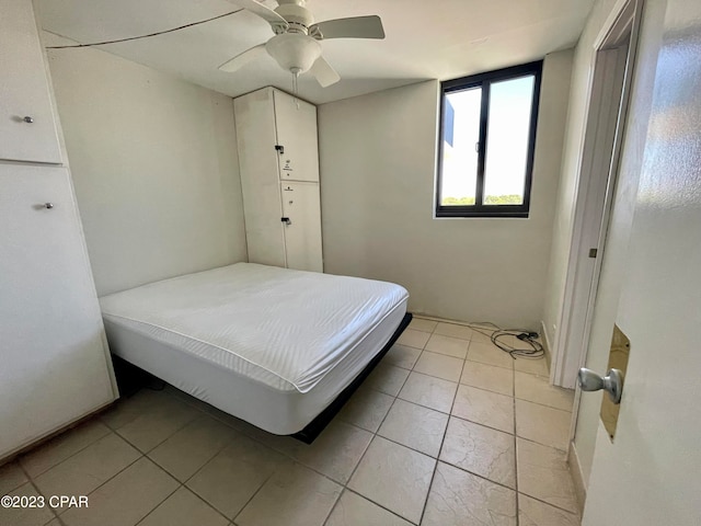 bedroom featuring ceiling fan and light tile floors