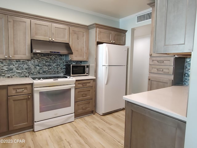 kitchen featuring under cabinet range hood, white appliances, visible vents, tasteful backsplash, and crown molding