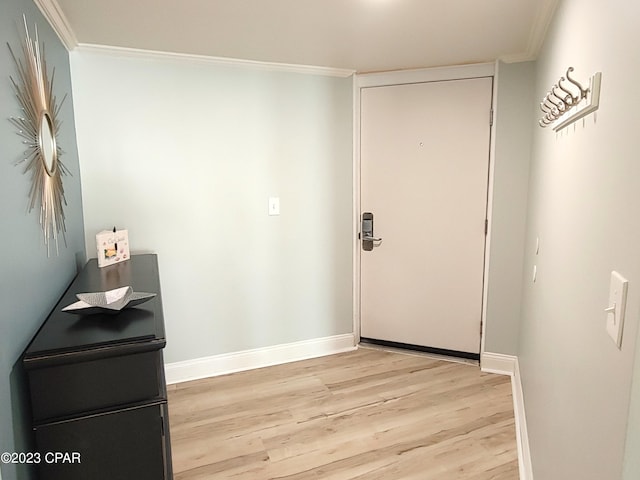 doorway featuring baseboards, ornamental molding, and light wood-style floors