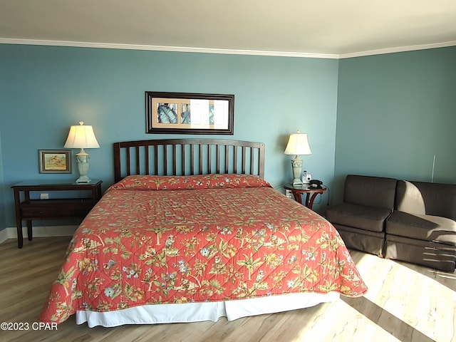 bedroom featuring baseboards, ornamental molding, and wood finished floors