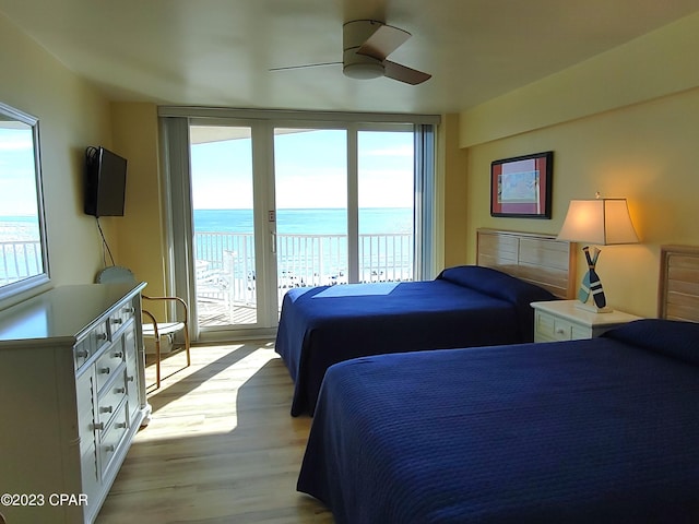 bedroom with access to outside, light wood-style floors, multiple windows, and floor to ceiling windows