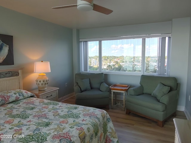 bedroom featuring ceiling fan, baseboards, and wood finished floors