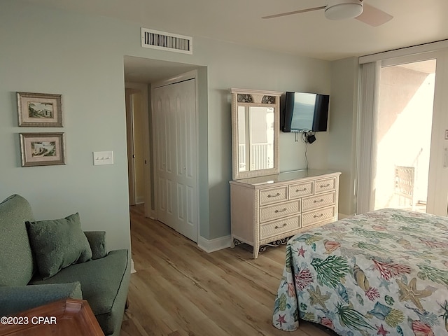 bedroom with a closet, visible vents, a ceiling fan, light wood-type flooring, and baseboards