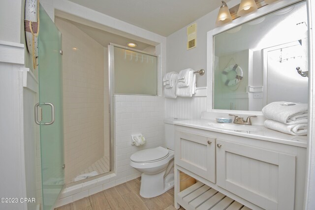 bathroom with vanity, wood-type flooring, toilet, and walk in shower