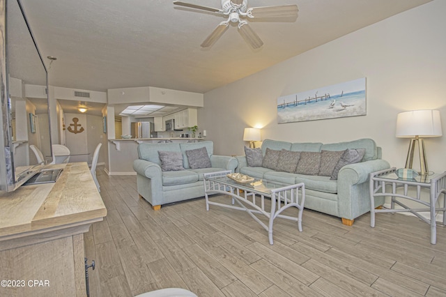 living room featuring light hardwood / wood-style floors and ceiling fan