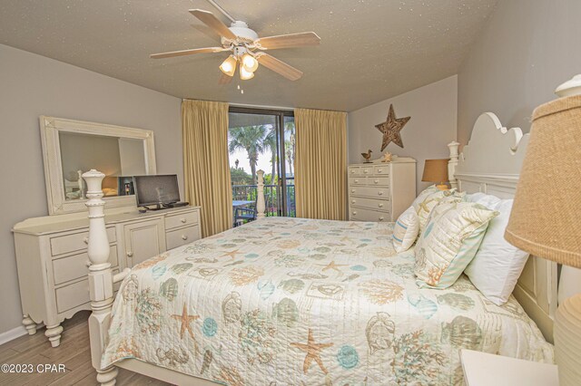 bedroom with ceiling fan, wood-type flooring, a textured ceiling, and access to outside