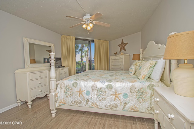 bedroom featuring light hardwood / wood-style flooring, ceiling fan, access to outside, and a textured ceiling