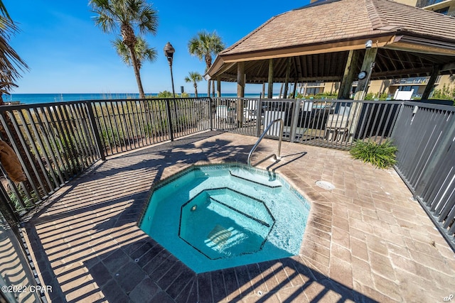 view of pool featuring a gazebo, a hot tub, and a water view