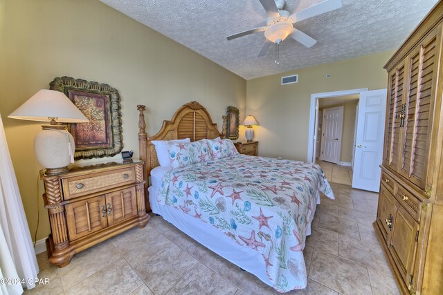 bedroom with ceiling fan and a textured ceiling