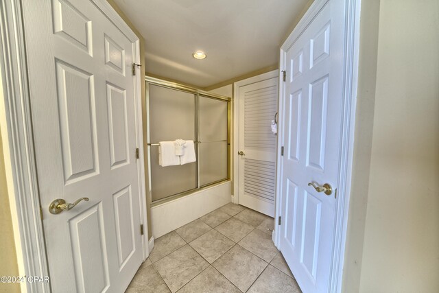 bathroom featuring bath / shower combo with glass door and tile patterned floors