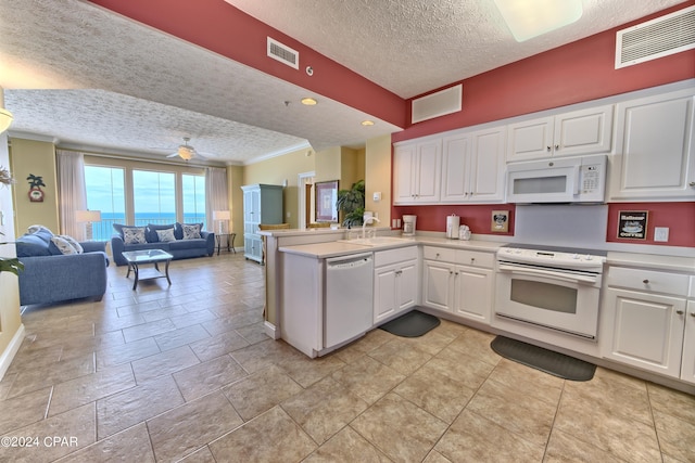 kitchen featuring sink, a textured ceiling, kitchen peninsula, white appliances, and white cabinets